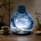 Lampe Bouddha rieur bleu ciel craquelée allumée dans une ambiance zen aux bambous.