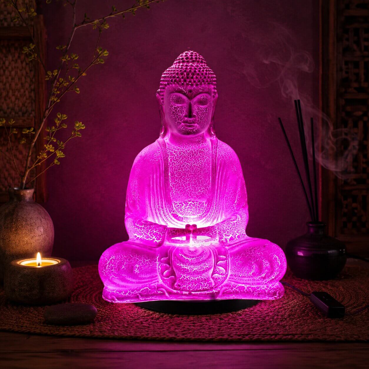 Lampe Bouddha rose cerise craquelée allumée dans une ambiance zen aux encens.