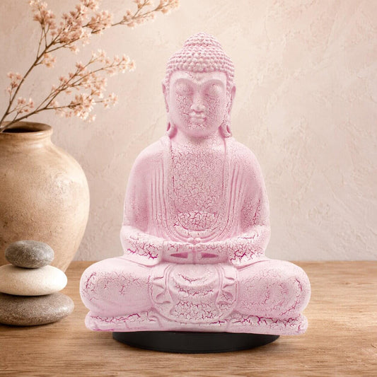 Lampe Bouddha rose cerise craquelée éteinte sur socle ovale noir en décor naturel.