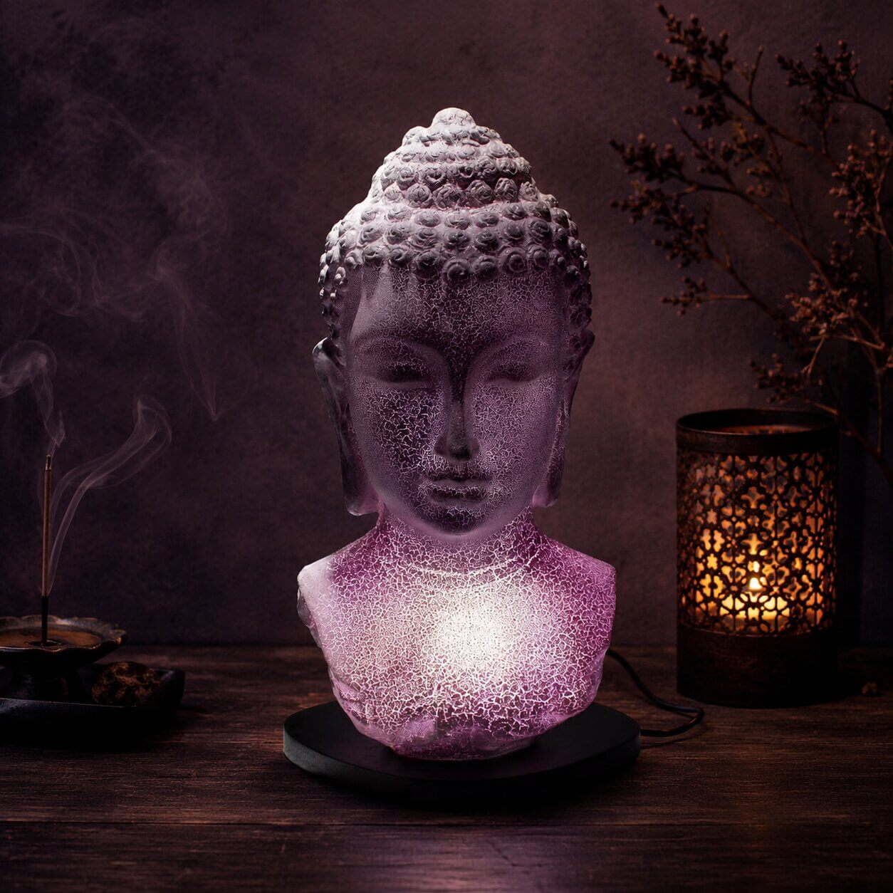 Lampe buste de Bouddha lavande craquelée allumée dans une ambiance zen aux encens