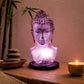 Lampe buste de Bouddha lavande craquelée allumée diffusant une lumière violacée dans un coin méditation.