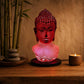 Lampe buste de Bouddha rouge craquelée allumée dans une ambiance zen aux bambous.