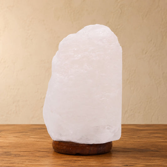 Lampe en cristal de roche blanc naturel de l'Himalaya sur socle en bois foncé.