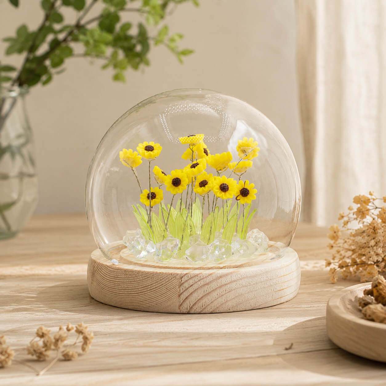 Lampe dôme aux 20 tournesols éteinte sur sa base en bois clair en décor naturel.