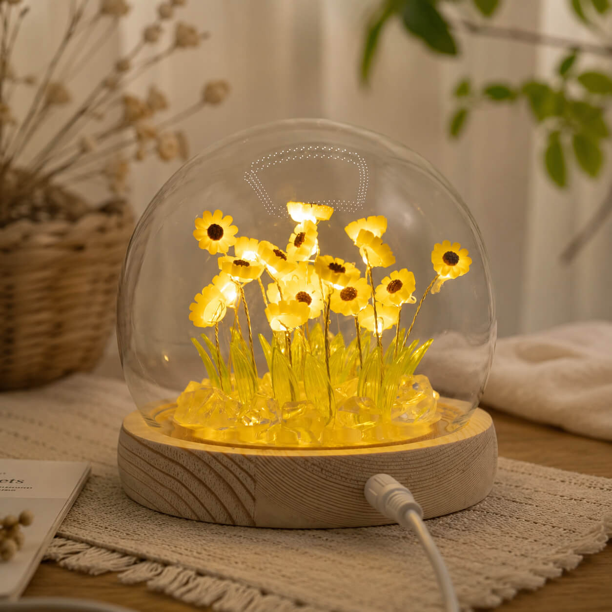 Veilleuse dôme aux 20 tournesols LED allumée sur un tapis tissé naturel.