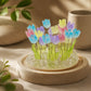 Lampe dôme aux 20 tulipes multicolores éteinte sur sa base en bois clair en décor naturel.