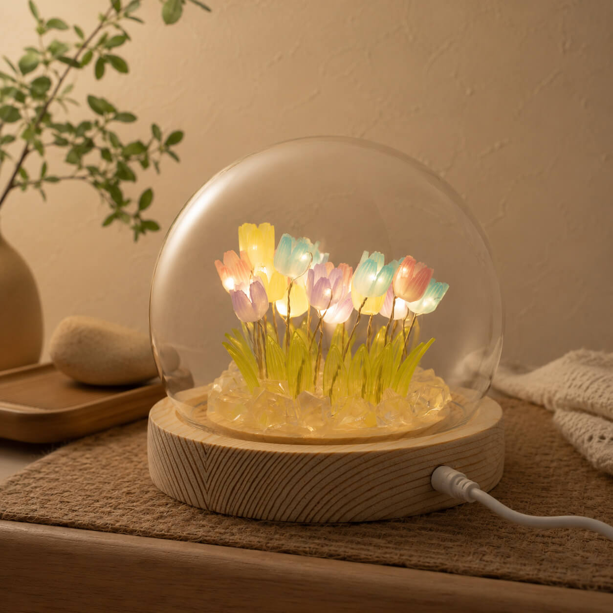 Veilleuse dôme aux 20 tulipes multicolores LED allumée sur tapis en fibre naturelle.