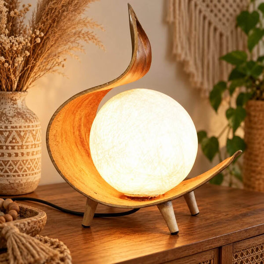 Lampe en feuille de coco torsadée allumée, sphère en fils de coton sur un buffet en bois