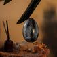 Lampe œuf de lave gris anthracite allumée en ambiance zen avec diffuseur d'encens.