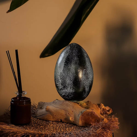 Lampe œuf de lave gris anthracite allumée en ambiance zen avec diffuseur d'encens.