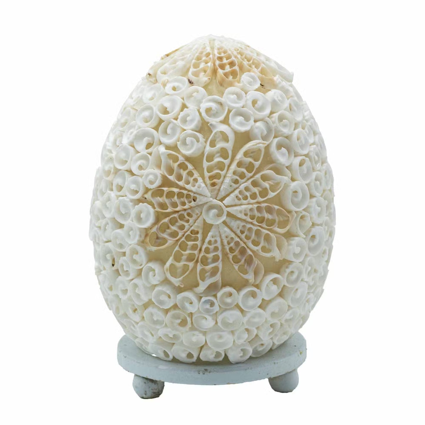 Lampe œuf nacré en coquillages assemblés en rosace florale sur socle blanc fond blanc