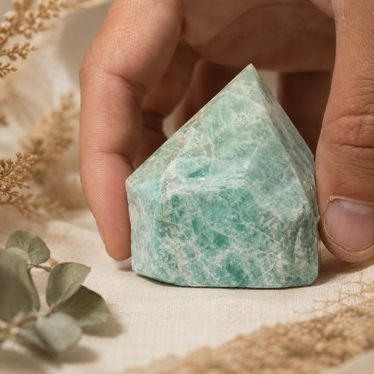 Pointe d'amazonite turquoise-vert à la pointe polie tenue en main