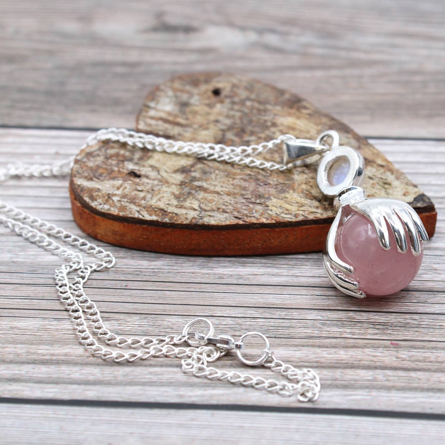 Pendentif mains guérisseuses en Quartz Rose avec chaîne sur un coeur en bois