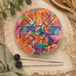 Petit tongue drum psychédélique 13cm vue de dessus avec ses mailloches sur tapis tressé