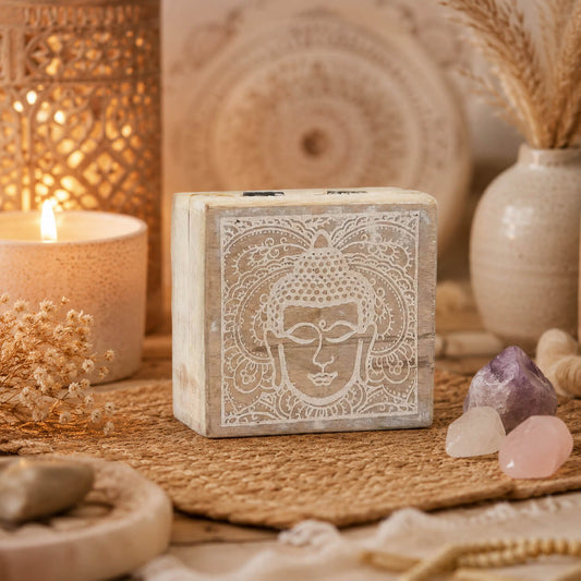 Petite boîte à bijoux carrée en bois avec visage de Bouddha gravé en blanc.