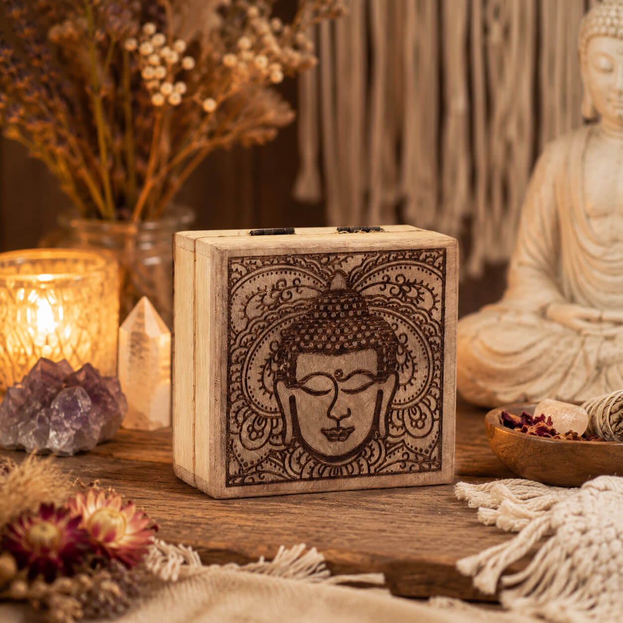 Petite boîte à bijoux carrée en bois avec visage de Bouddha gravé en noir sur fond blanchi.