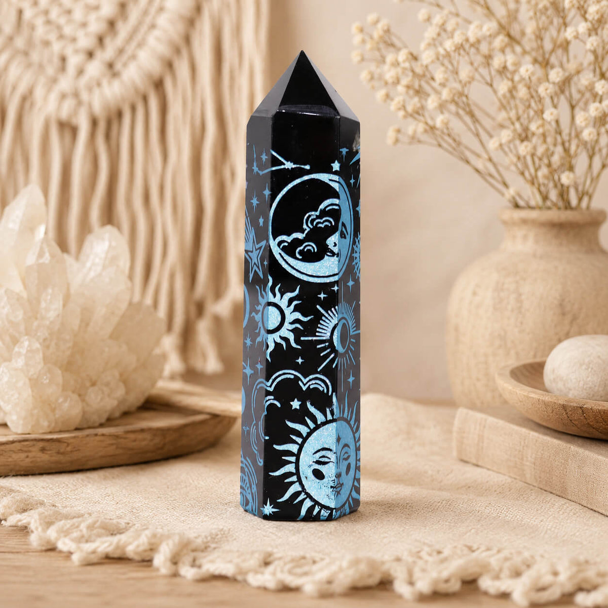 Pointe d'obsidienne noire gravée d'une lune, d'un soleil et d'étoiles en bleu ciel