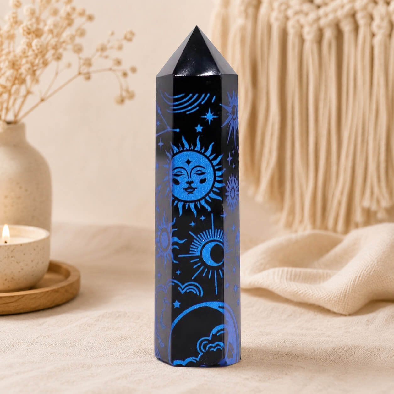 Pointe d'obsidienne noire gravée d'un soleil au visage et d'étoiles en bleu