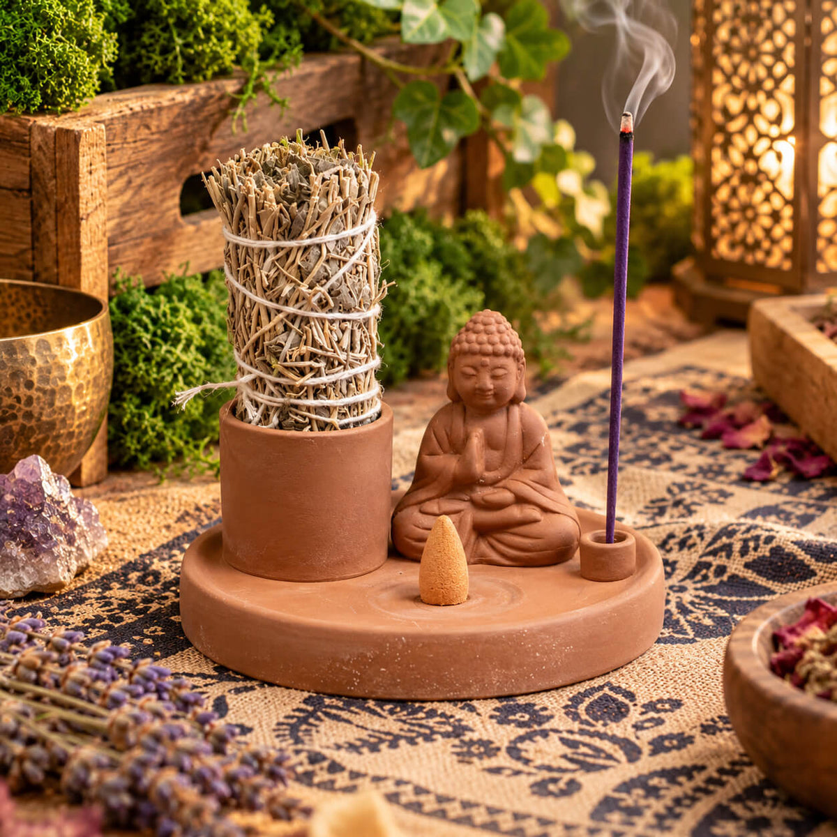 Porte-encens Bouddha en céramique garni d'un bâton de sauge, d'un cône et d'un bâtonnet d'encens violet allumé