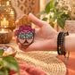 Porte-encens Hamsa en pierre à savon tenu dans la main, montrant l'arbre de vie gravé et ses couleurs vives