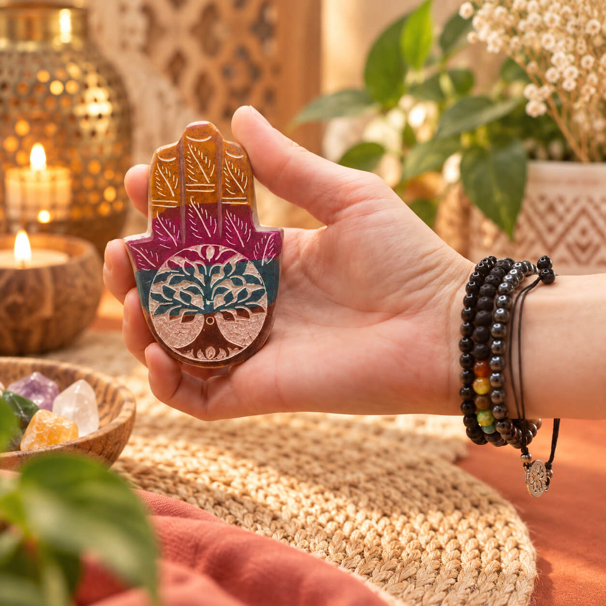 Porte-encens Hamsa en pierre à savon tenu dans la main, montrant l'arbre de vie gravé et ses couleurs vives