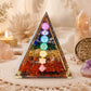 Pyramide en orgonite avec les sept couleurs et symboles des chakras superposés