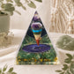 Pyramide en orgonite avec pendule multicolore suspendu au-dessus d'un médaillon étoilé