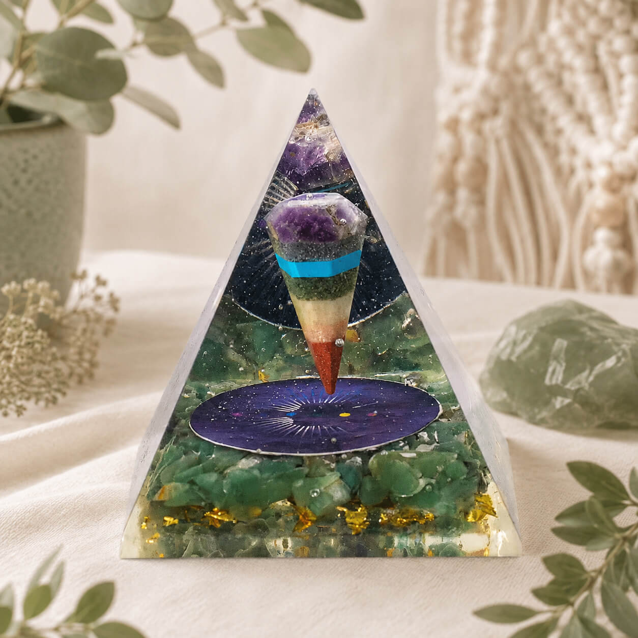 Pyramide en orgonite avec pendule multicolore suspendu au-dessus d'un médaillon étoilé