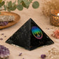 Pyramide orgonite posée dans une ambiance méditative avec bougie, sauge blanche et améthyste