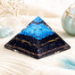 Pyramide en orgonite montrant les fils de cuivre doré traversant la base sombre