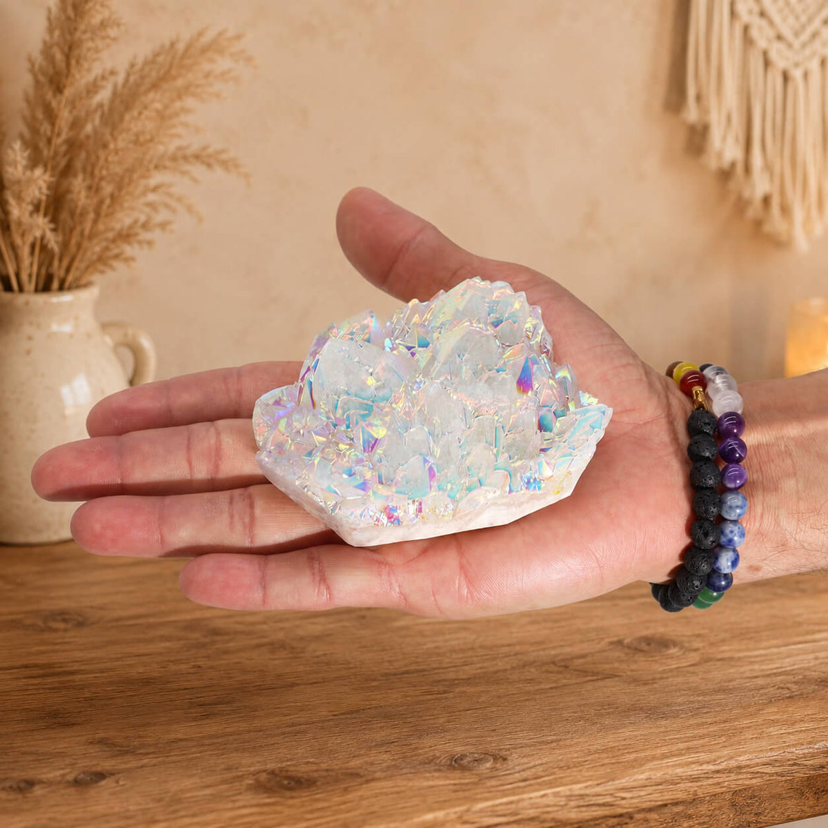 Quartz Aura Angélique tenu dans une main avec bracelets en pierres naturelles