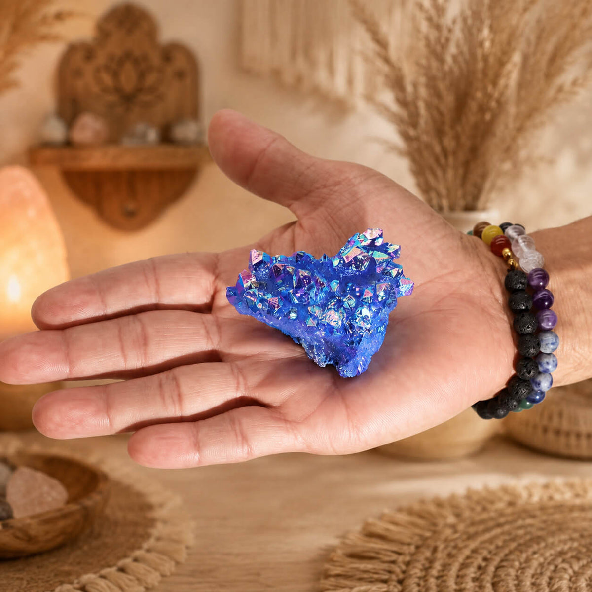 Quartz Aura Aqua Halo tenu dans une main avec bracelets en pierres naturelles