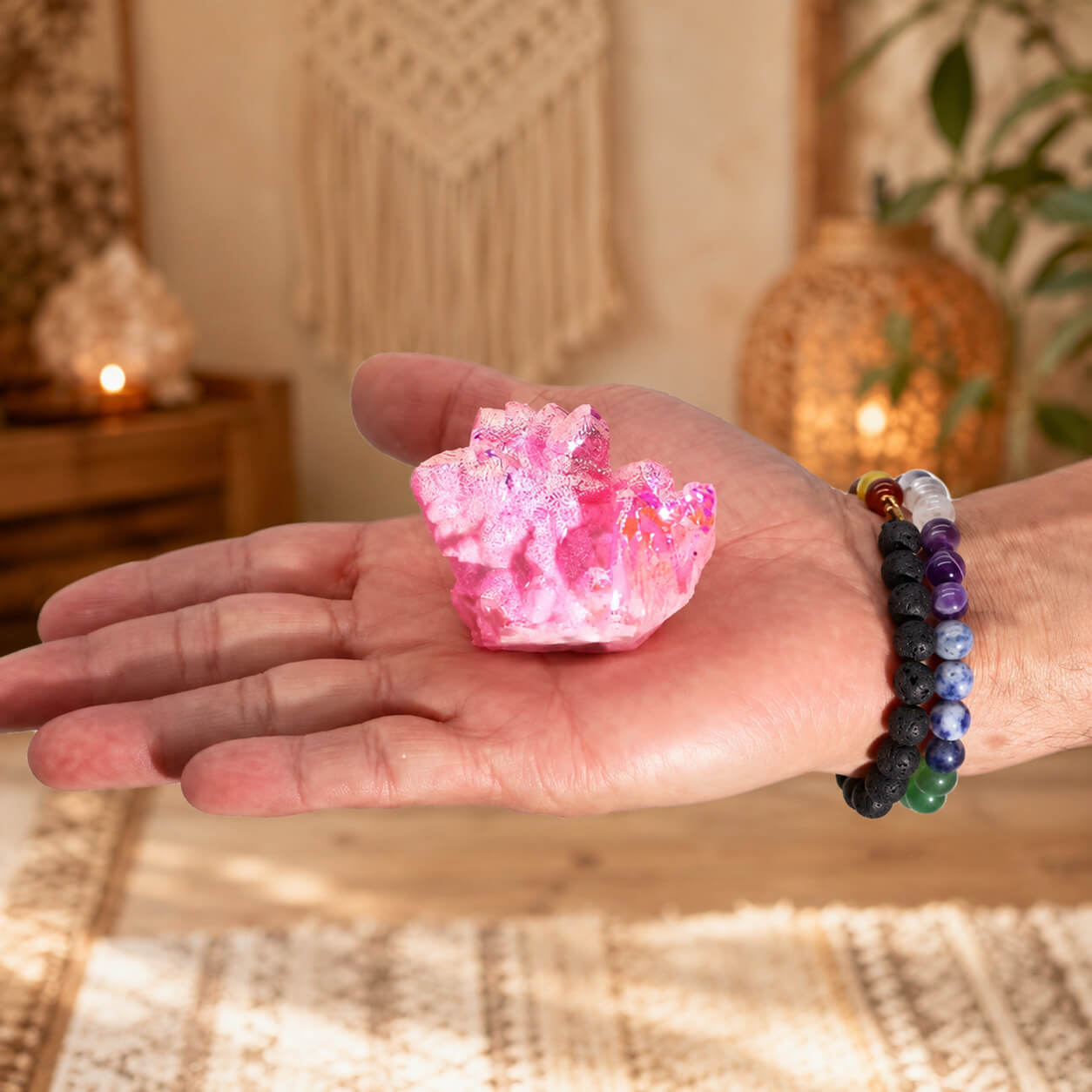 Quartz Aura Rose Halo tenu dans une main avec bracelets en pierres naturelles