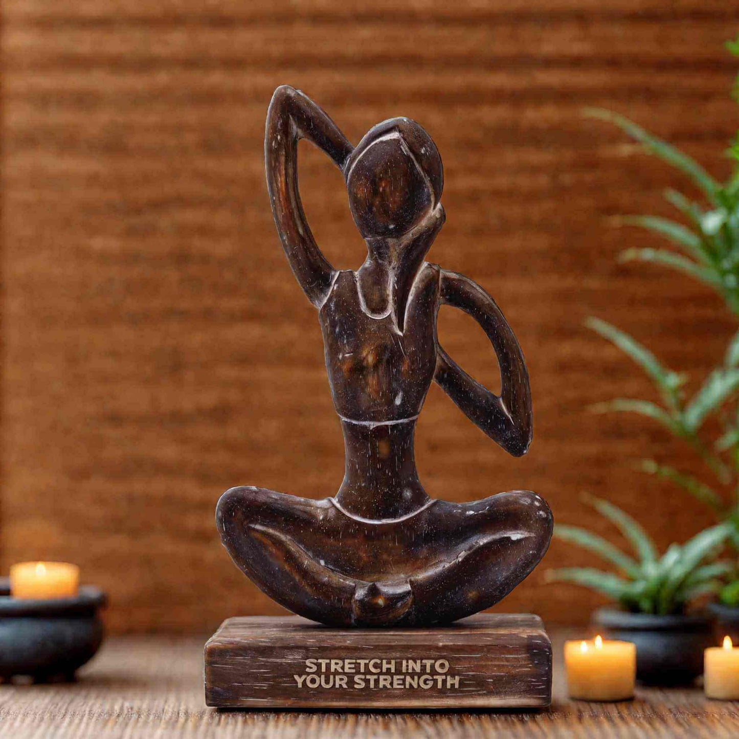 Statue femme de yoga en bois foncé représentant une posture d'étirement latéral, sur socle gravé du mantra 'STRETCH INTO YOUR STRENGTH