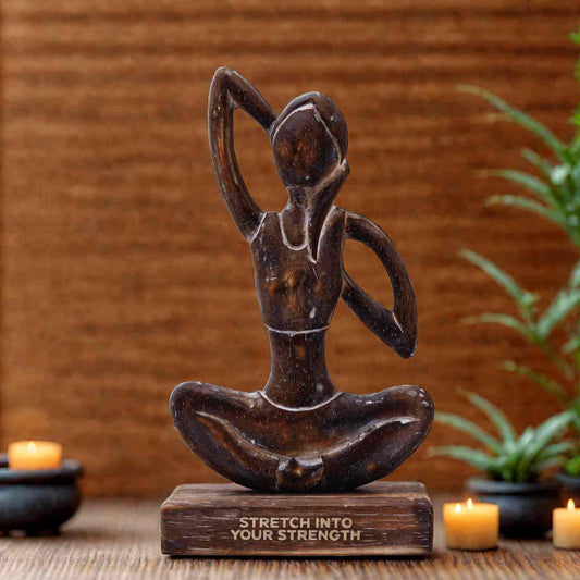 Statue femme de yoga en bois foncé représentant une posture d'étirement latéral, sur socle gravé du mantra 'STRETCH INTO YOUR STRENGTH