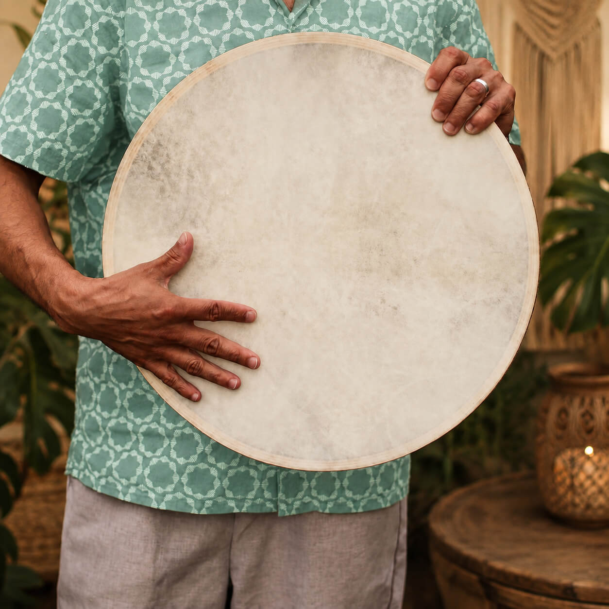 Tambour chamanique océanique 45 cm tenu à deux mains, prêt à être joué.