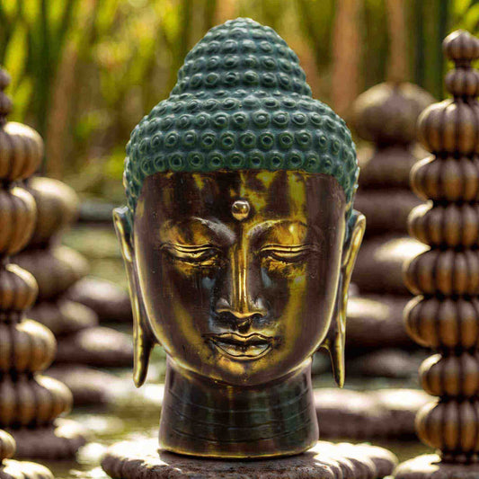 Tête de Bouddha en laiton à la coiffe turquoise patinée et au visage bronze antique, expression sereine.