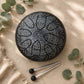 Tongue drum 16cm noir mat gravé d'un mandala tribal argenté avec symbole Om et deux mailloches métalliques