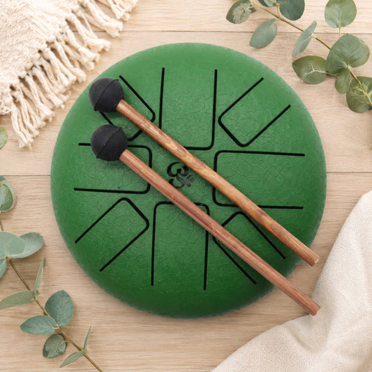 Vue de dessus du tongue drum vert émeraude 16cm révélant les huit langues mélodiques en acier trempé et le symbole Om central.